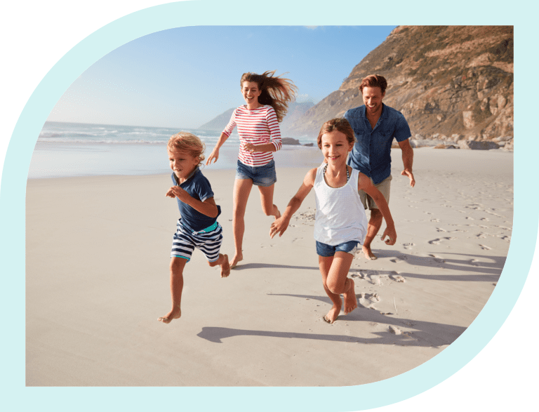 Family running joyfully on a sunny beach.