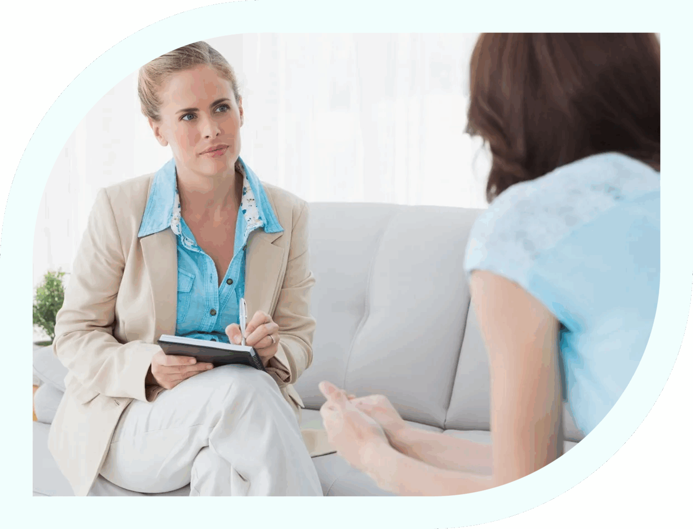 A counselor attentively listens to a client during a therapy session.